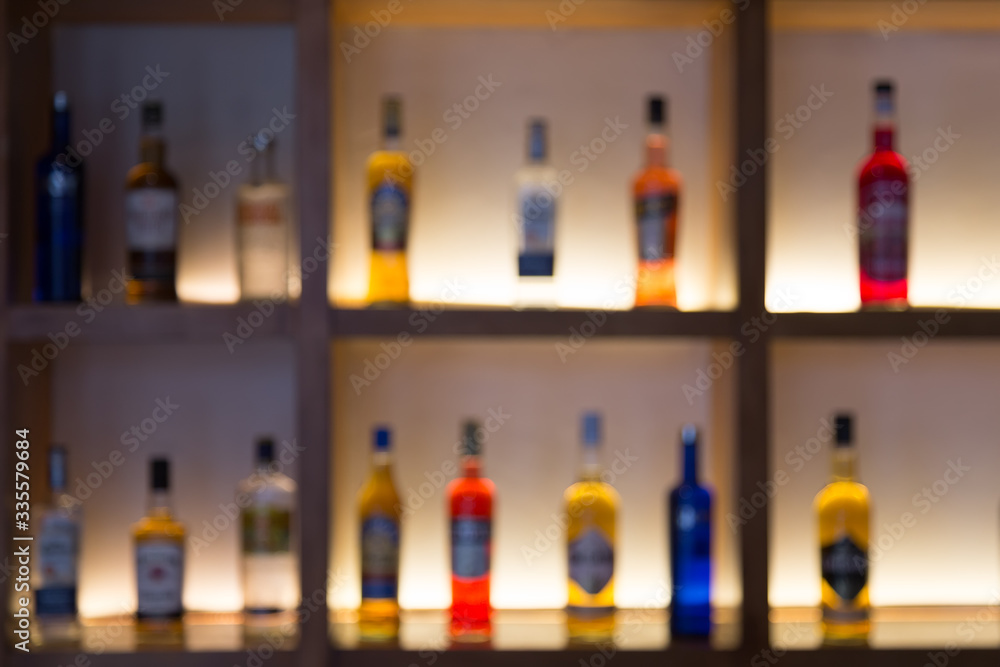 Defocused background of various alcohol bottles in a bar or restaurant. Bar advertisement mockup image Defocused background of various alcohol bottles in a bar or restaurant. Bar advertisement mockup image