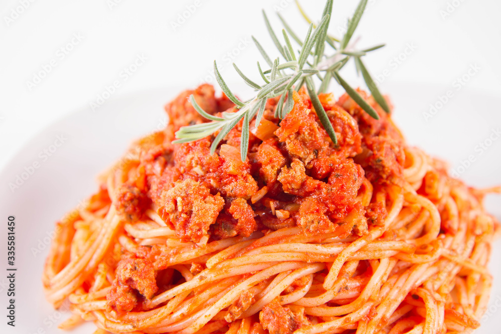 Spaghetti bolognese on a plate decorated with a rosemary twig Spaghetti bolognese on a plate decorated with a rosemary twig