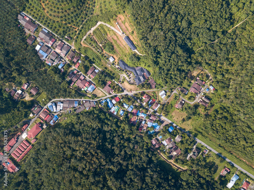 Aerial view look down Kampung Baru Bukit Besar housing estate near plantation farm.