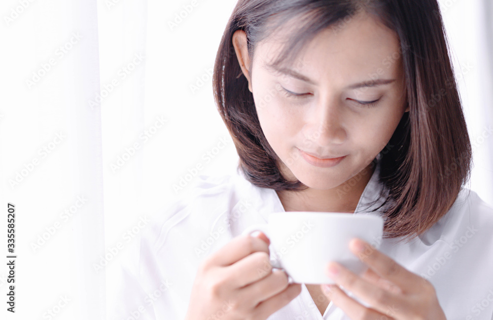 Closeup woman hand holding glass of hot americano coffee, selective focus, vintage tone Closeup woman hand holding glass of hot americano coffee, selective focus, vintage tone