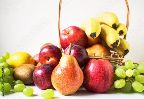 Assortment of fruit in a wooden basket on a white background. The concept of healthy eating. Copy space.