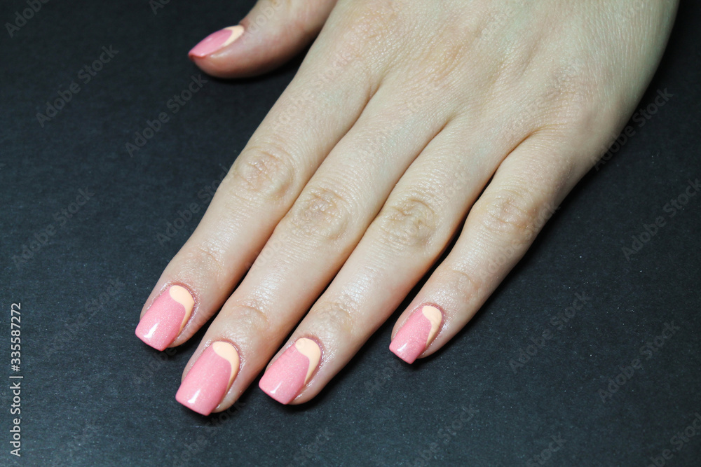 Naklejka premium Beautiful female hand with manicure coral gel Polish and hand drawn design
