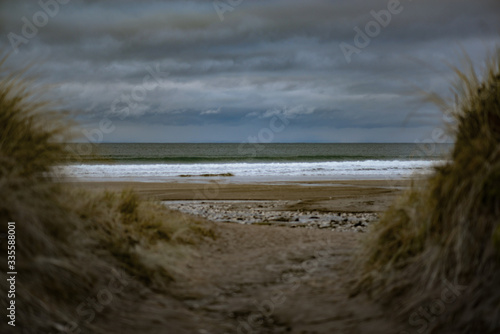 Sand path opens onto the sea at Whitepark Bay, Causeway Coast, Northern Ireland, UK photo