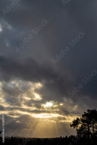 The sun's rays shine through the clouds. Cloudy skies. Sunset landscape.