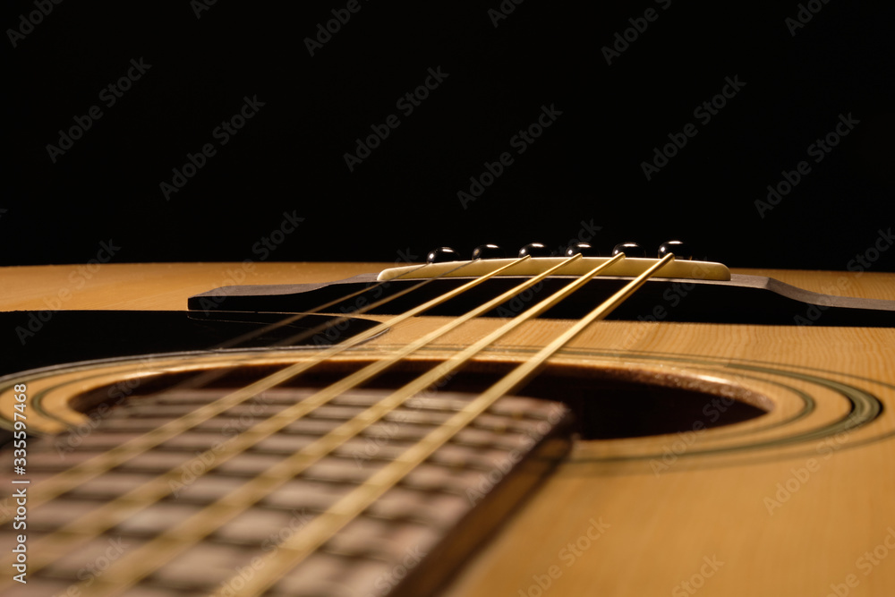 Acoustic guitar close up on a black background Acoustic guitar close up on a black background