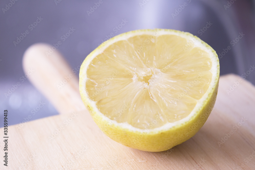 Half lemon cut on wooden cutting board