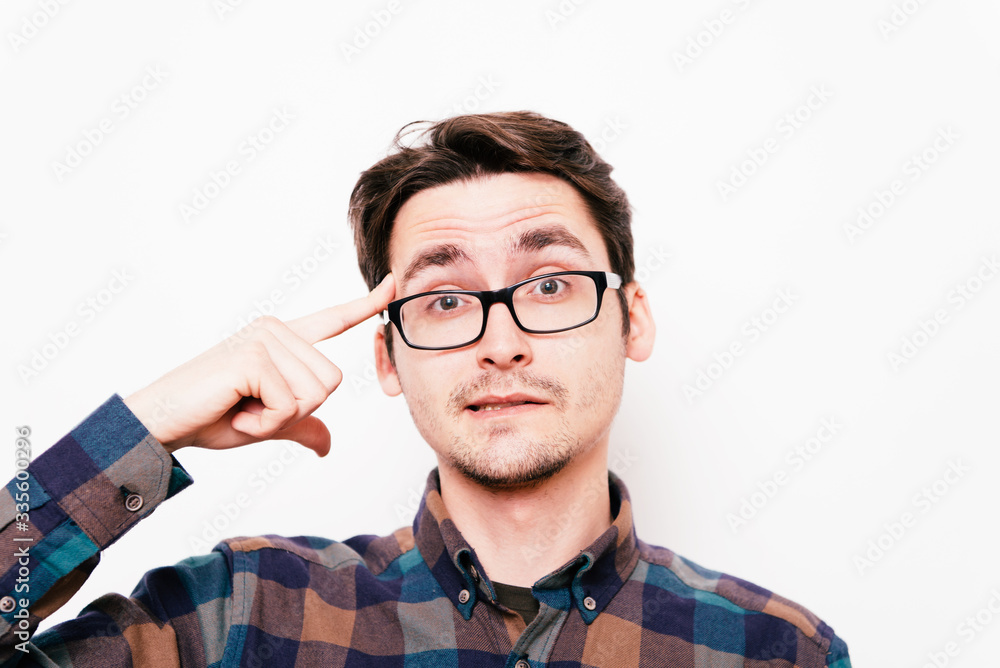 Closeup portrait of angry man gesturing with his finger against his temple, are you crazy? Closeup portrait of angry man gesturing with his finger against his temple, are you crazy?