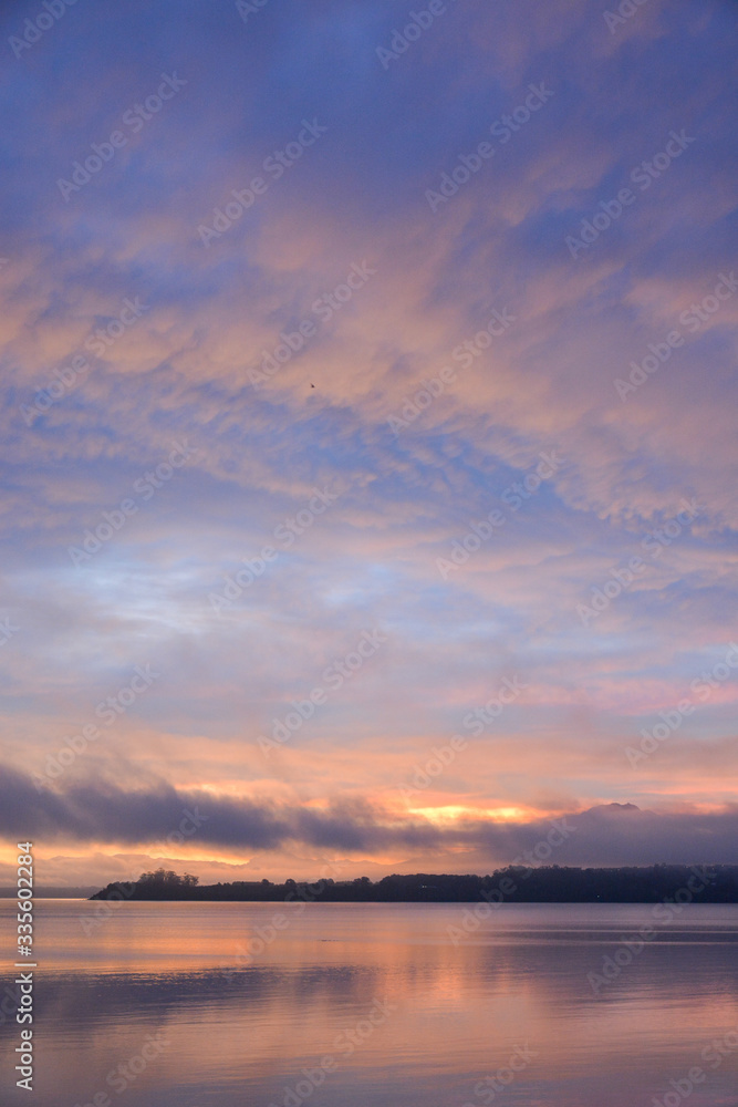 sunrise over lake with mountain in distance