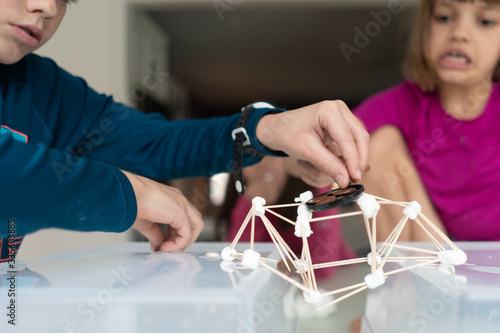Children building a suspension bridge of out marshmallows and toothpicks for a STEAM lesson photo