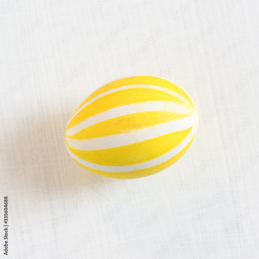 A traditional colored chicken egg for the spring festival Easter ritual. Yellow drawing