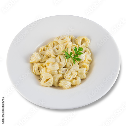 Dish of tortellini stuffed with meat and cream and a sprig of parsley.