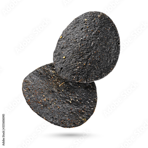 Fényképezés Two black potato chips isolated on white background.
