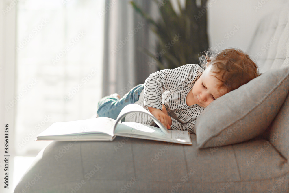 A little girl about 2 years old. In a light interior of neutral colors