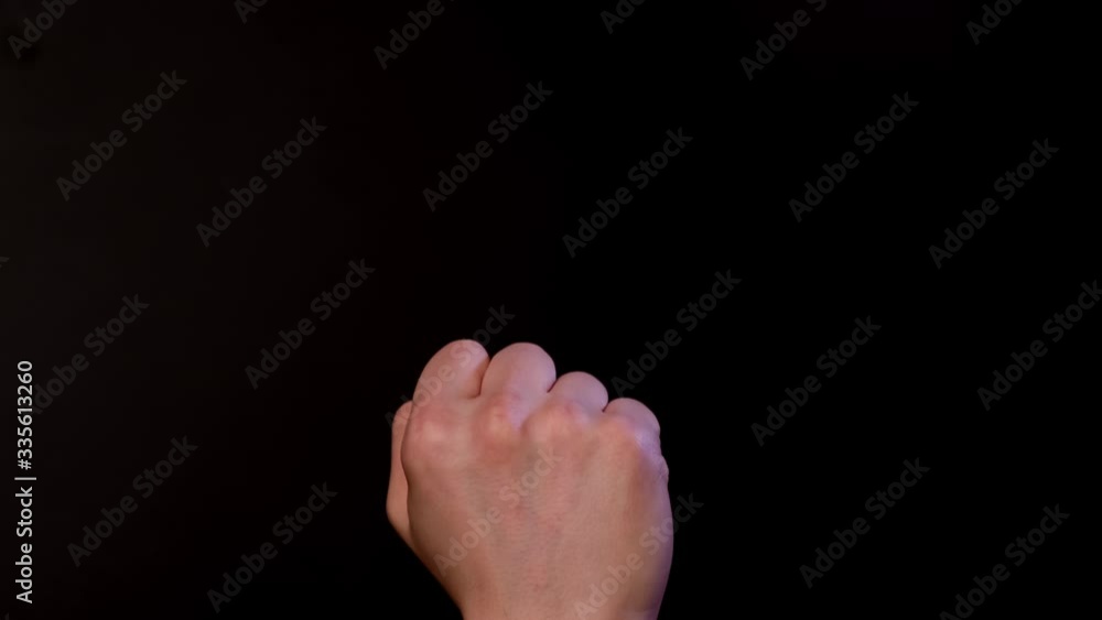 Hand shows the middle finger on black background Hand shows the middle finger on black background