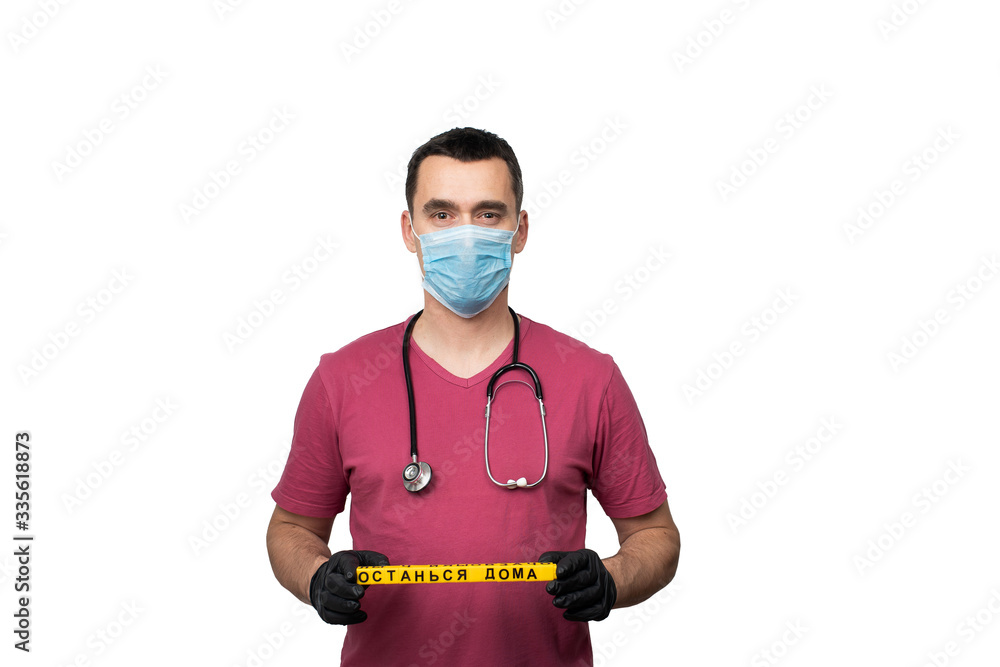 A doctor in a surgical mask holds the sign