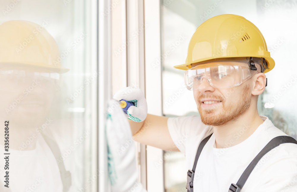 Worker in installing white plastic upvc window on house Worker in installing white plastic upvc window on house