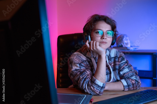 Freelancer desinger working from home using graphic tablet and stylus with neon light at the back