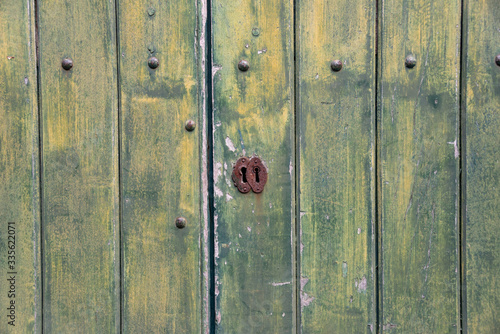 Green, wooden, vintage background with keyhole.  © Maciej