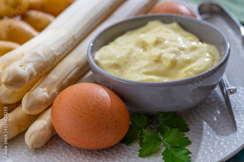 Ingredients for spring vegetarian dinner, high quality Dutch white asparagus, washed and peeled on board, ready to cookand, young potatoes, eggs and sauce photo