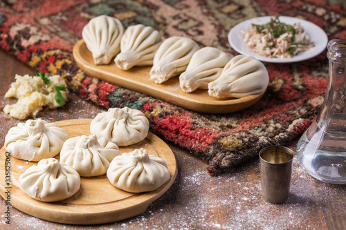 Georgian dumplings Khinkali with potato and mushroom, Vegan food, Georgian Chacha (vodka) on a wooden background