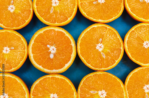 top view of juicy fruit halves orange located on a blue background
