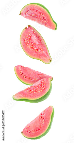 Guava fruit pieces in the air. Five slices of fresh guava with pink flesh falling over white background