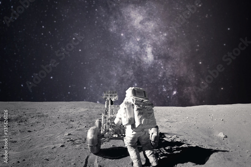 Astronaut on rock surface with space background. Elements of this image furnished by NASA