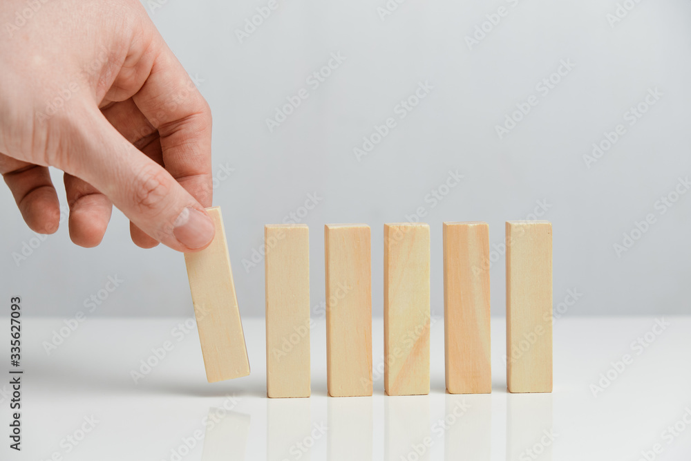 The concept of creating a phased business. Hand holds wooden blocks on a white background. The concept of creating a phased business. Hand holds wooden blocks on a white background.