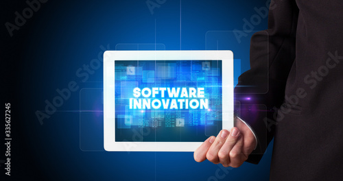 Wallpaper Mural Young business person working on tablet and shows the inscription: SOFTWARE INNOVATION Torontodigital.ca