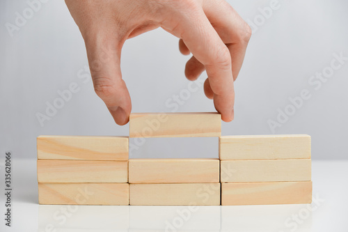 The concept of basic tasks. Hand holds wooden blocks on a white background.