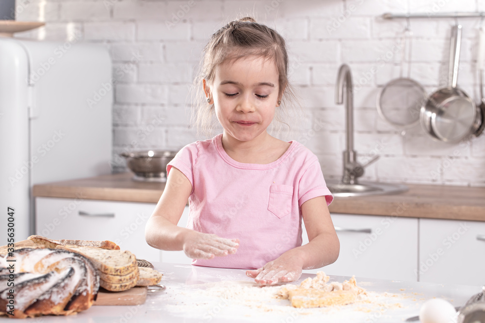 A cute little girl is cooking homemade cakes in the kitchen. A cute little girl is cooking homemade cakes in the kitchen.
