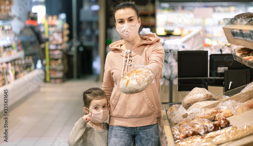 A young woman shopping in a supermarket during a virus epidemic. photo