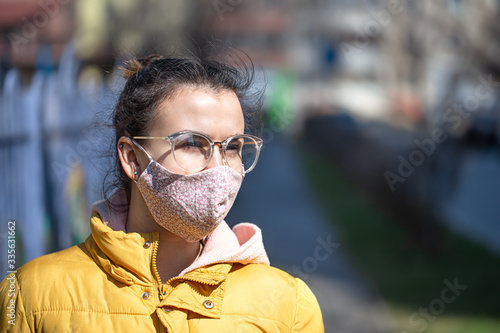 A young woman in a mask during the pandemic. Coronavirus. © puhimec