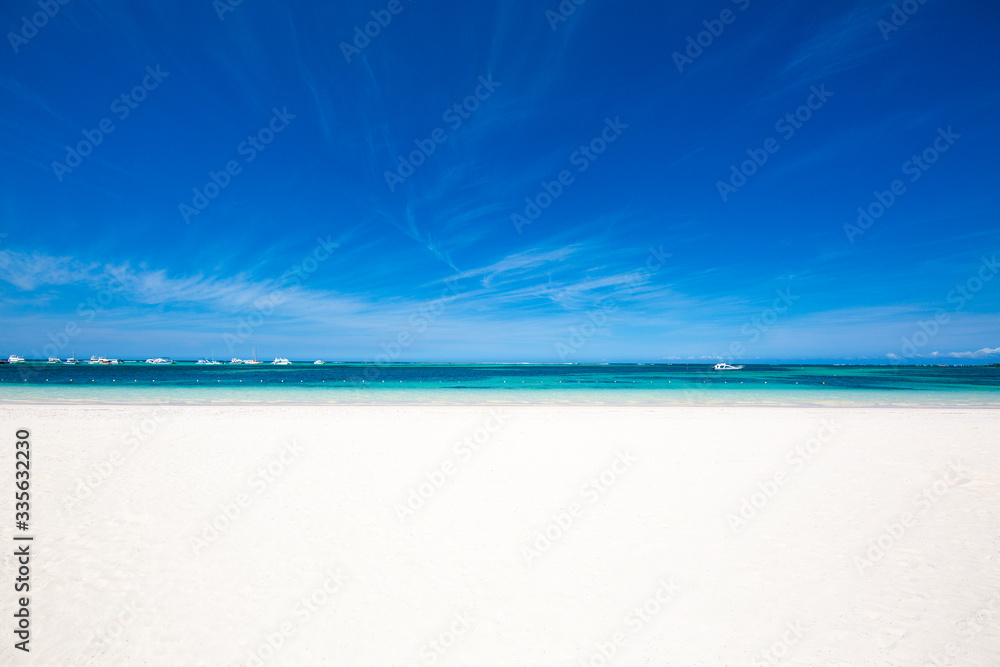 Large beach with white sand and turquoise water of the Caribbean Sea. clear blue sky on the horizon. Beautiful tropical background