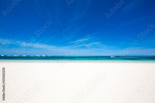 Large beach with white sand and turquoise water of the Caribbean Sea. clear blue sky on the horizon. Beautiful tropical background