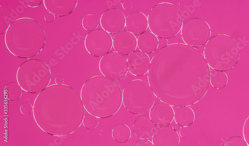 round oily soap bubbles on a pink background