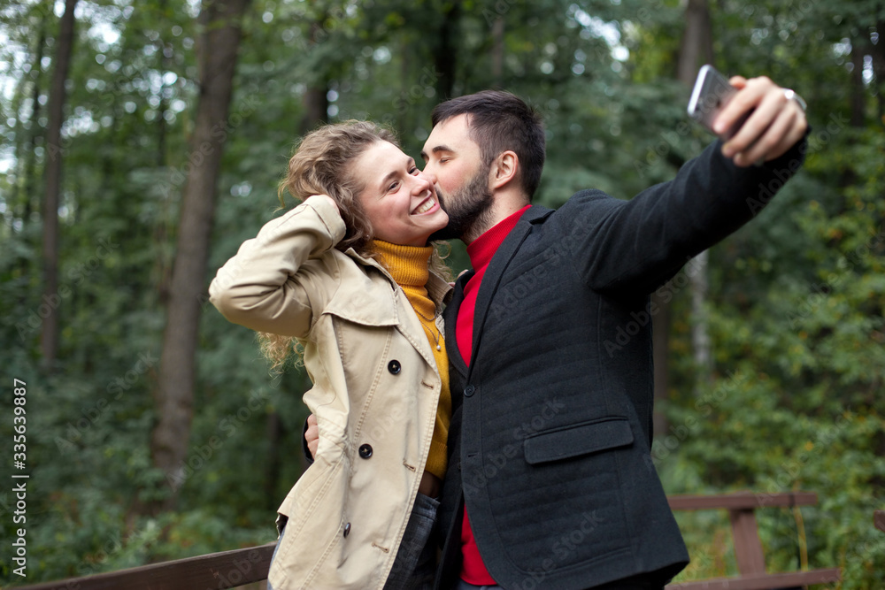 Young couple take selfies on smartphone in park Young couple take selfies on smartphone in park