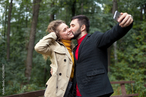 Young couple take selfies on smartphone in park