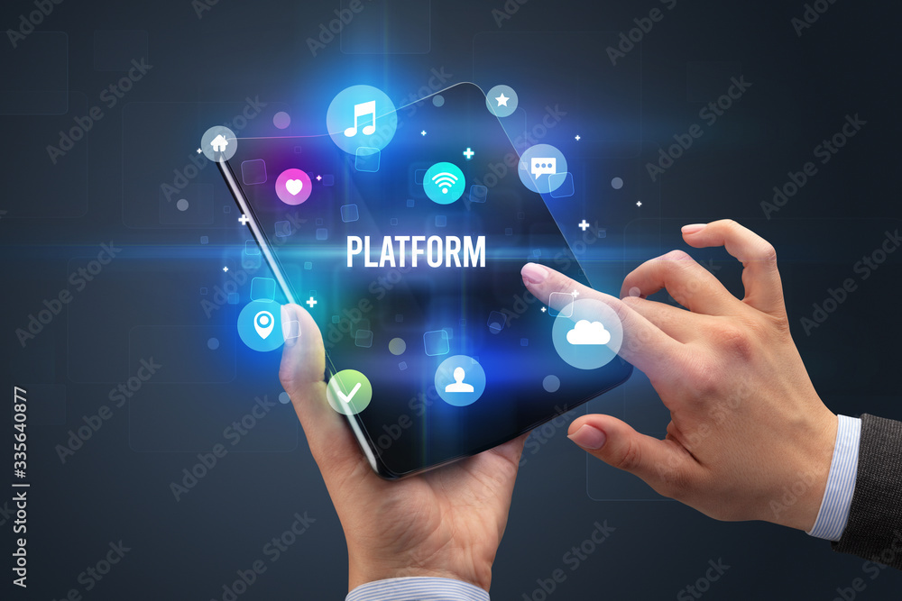 Businessman holding a foldable smartphone with PLATFORM inscription, social media concept Businessman holding a foldable smartphone with PLATFORM inscription, social media concept