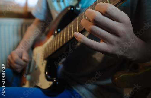 Male hands playing electric solo guitar with closeup photo. Learning musical instrument, music shop or school, blues bar or rock cafe, having fun enjoying hobby concept