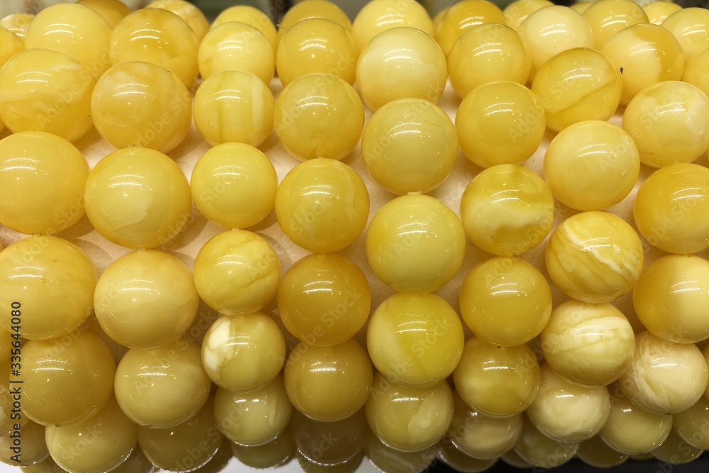 Bracelets made of white Baltic amber balls on a jewelry stand in the shop window. Bracelets made of white Baltic amber balls on a jewelry stand in the shop window.
