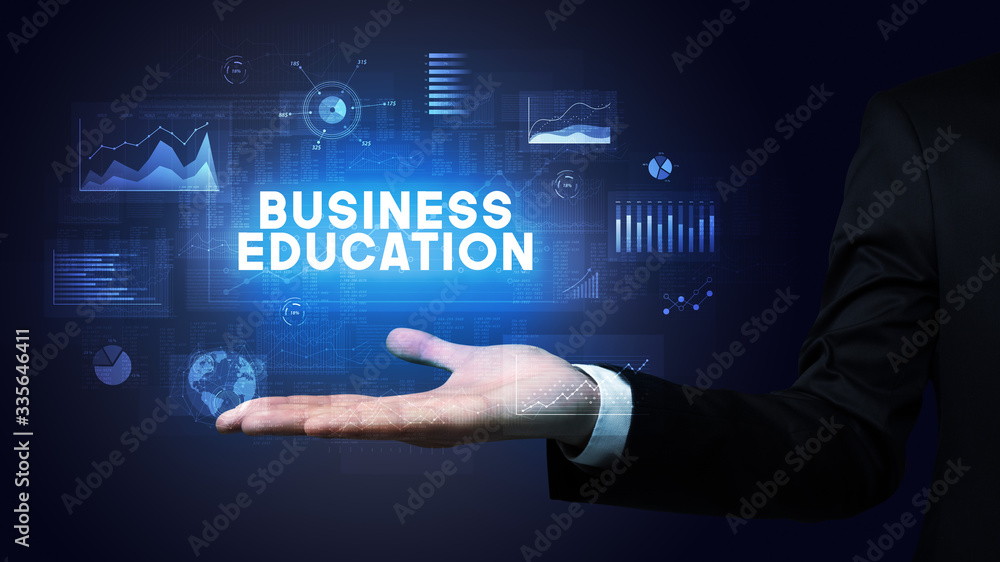 Hand of Businessman holding BUSINESS EDUCATION inscription, business success concept Hand of Businessman holding BUSINESS EDUCATION inscription, business success concept
