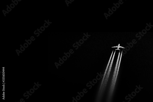 Abstraction: plane (A380) emitting contrails while cruising in a dark sky.