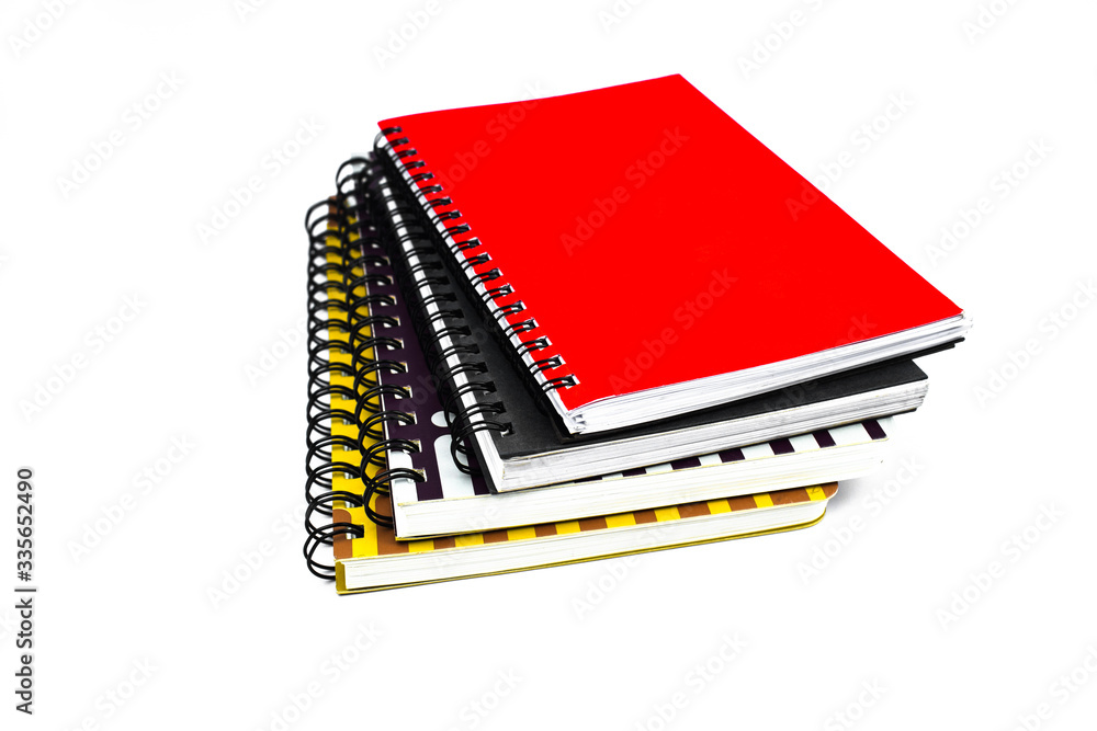 Side view of four different color covered paper note books gathered on top of each other Side view of four different color covered paper note books gathered on top of each other