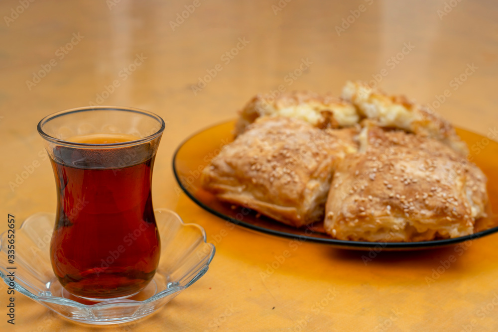 Delicious homemade burrito slices and tea , ready to eat. Turkish borek slices. Delicious homemade burrito slices and tea , ready to eat. Turkish borek slices.