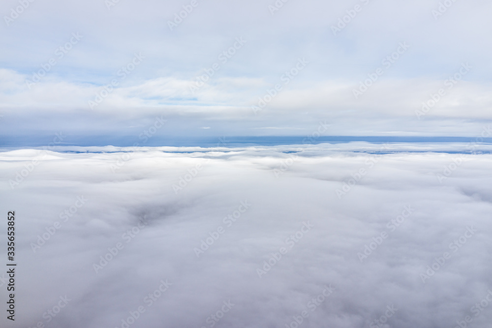White clouds and blue sky horizon aerial view from window plane high angle during day from Ukraine to Poland