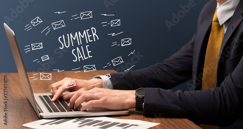 Businessman working on laptop with SUMMER SALE inscription, online shopping concept