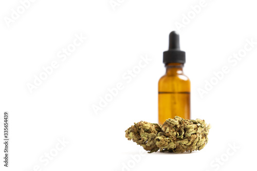 Cannabis oil in glass bottle and marijuana bud isolated on white background