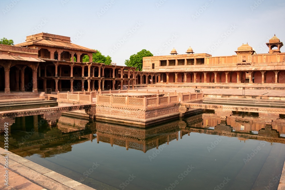 Fatehpur Sikri with a lot of columns located in Uttar Pradesh, India reflected in a pool