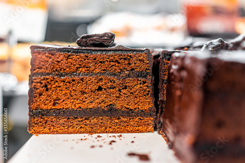 Closeup of display of brown gingerbread sponge chocolate layer cake and sign in Polish in Warsaw, Poland cafe at Christmas photo